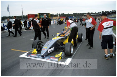 Timo Glock mit Mechanikern in der Startaufstellung